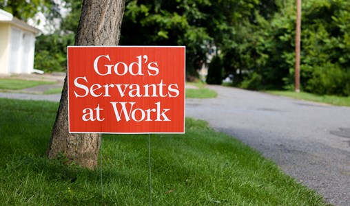 A sign on the grass that says