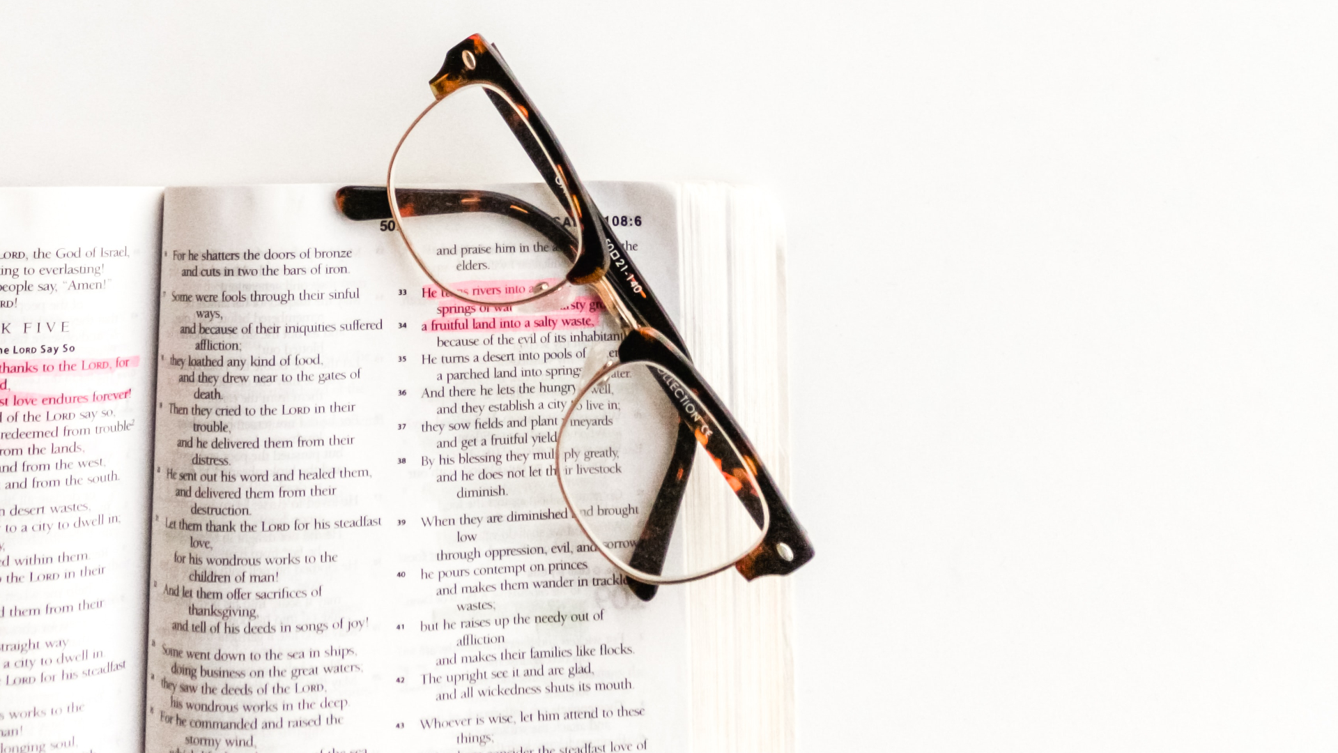 A picture of a bible with a reading glasses placed at the top