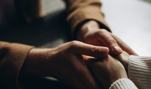People holding hands showing sympathy and a tender-heart